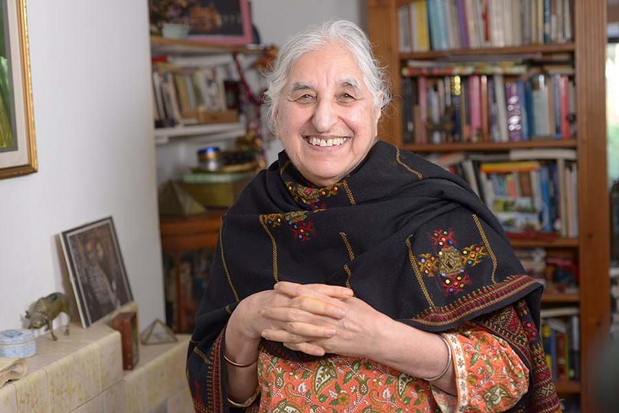 A person clasping their hands looking at the camera