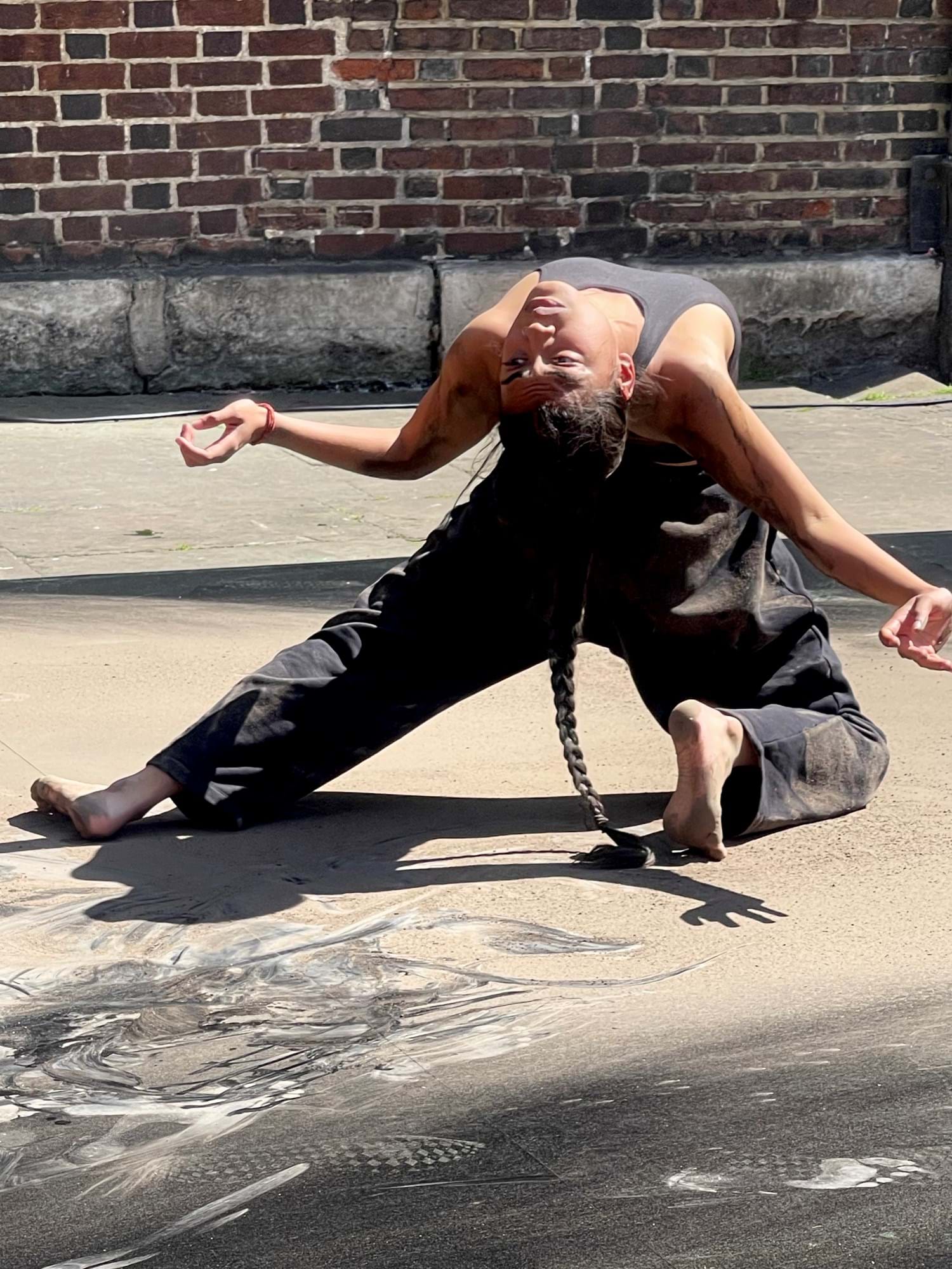 A person bends backwards on their knees