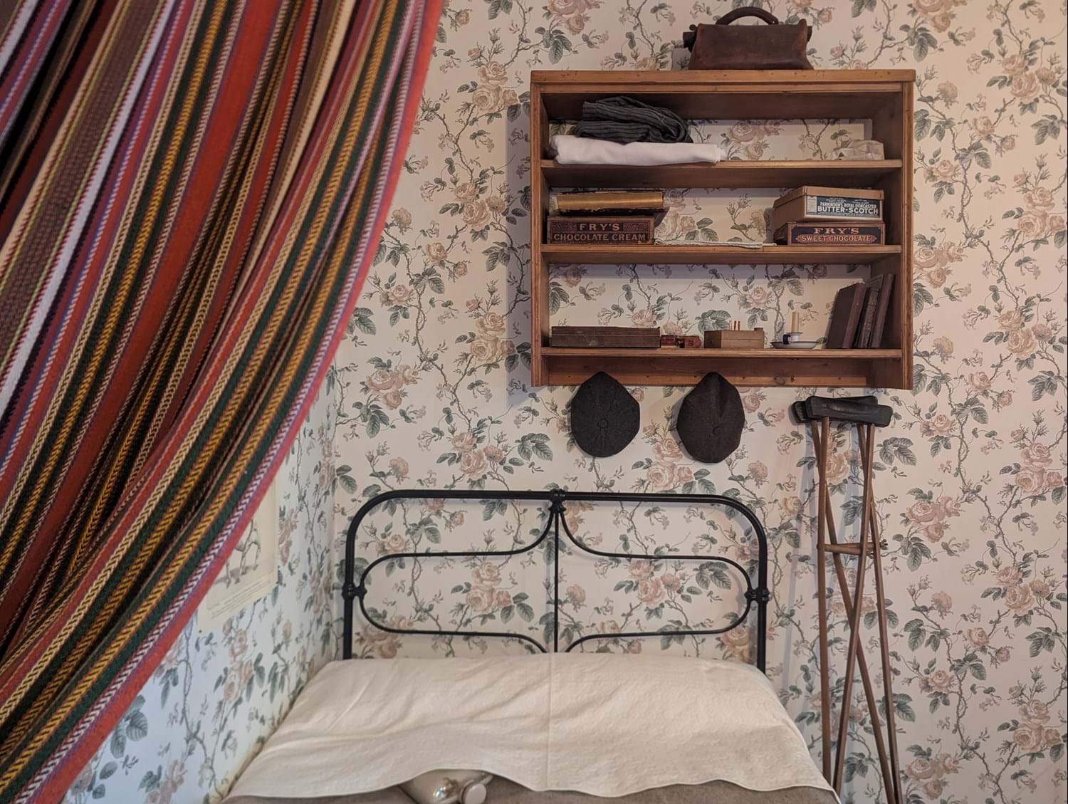 Bed, curtain, bookshelf, and crotches in A Tenement Flat in 1913 at Museum of the Home