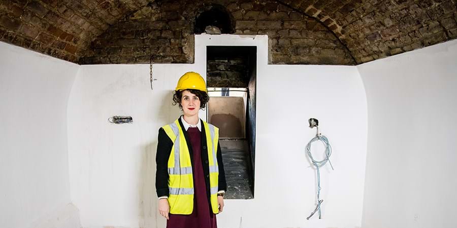 Director Sonia Solicari standing in a hardhat by the coalchute in the Undercroft