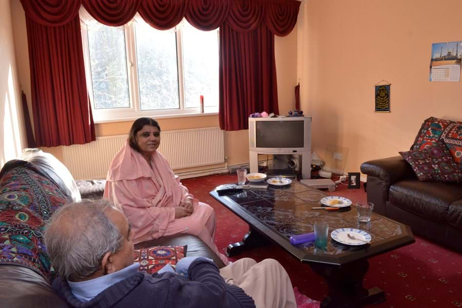 Two people sitting on the sofa in a living room