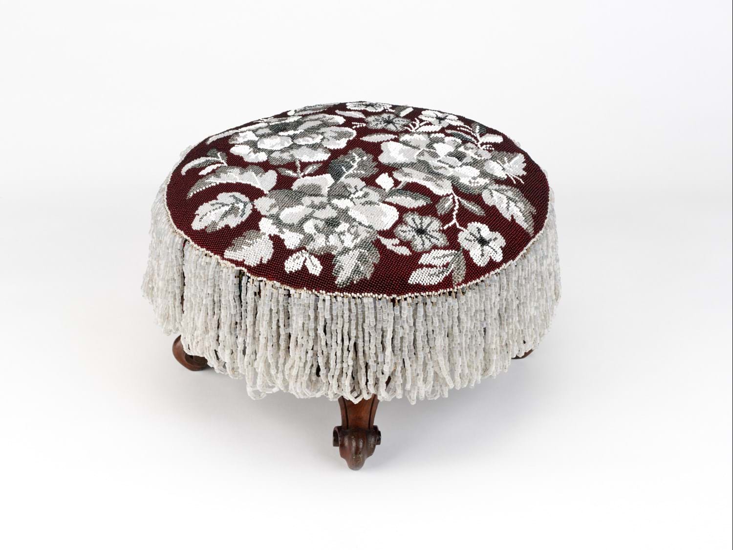 Red footstool with ornate white bead decoration