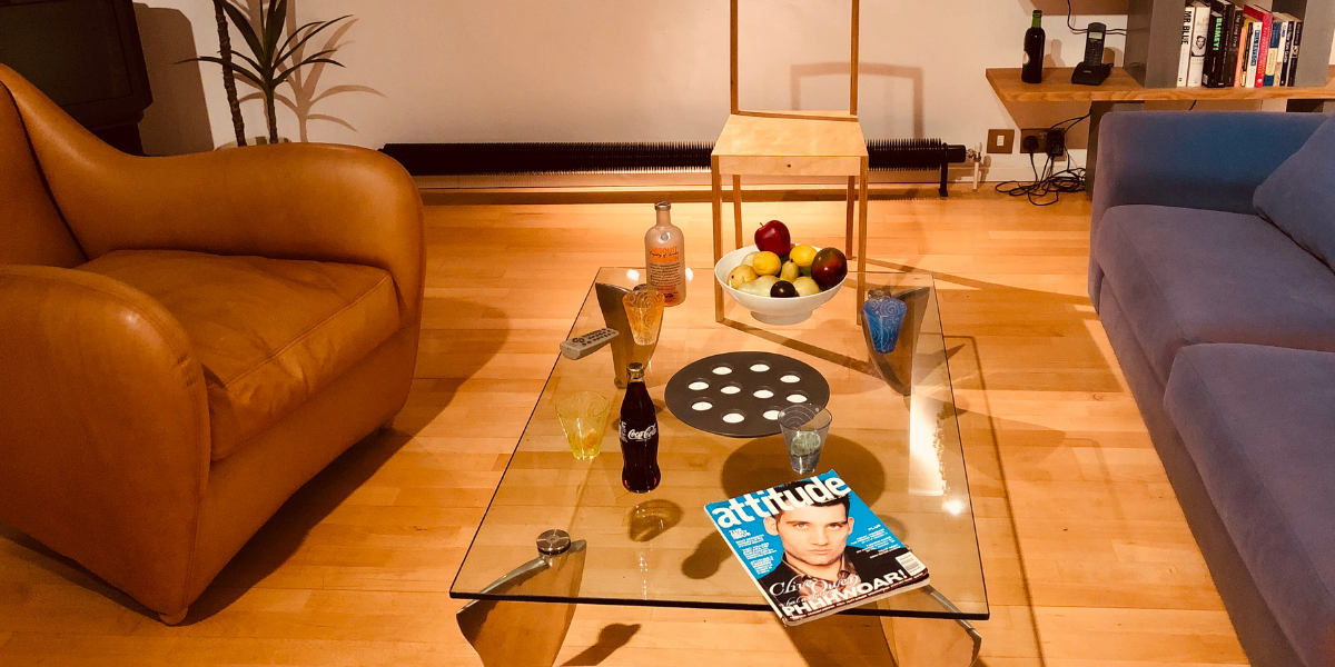 Glass table in 1990s room with Attitude magazine visible