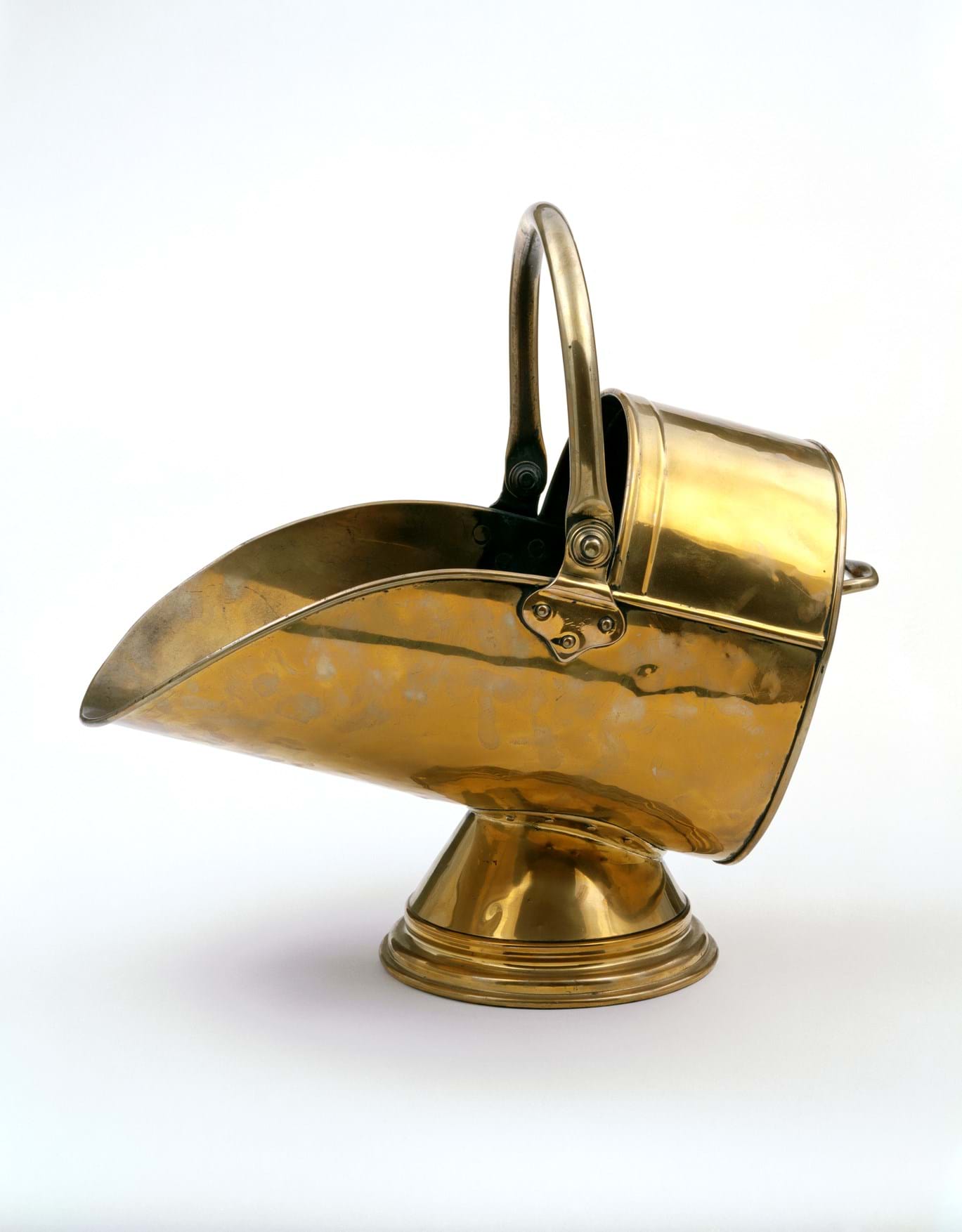 A helmet-shaped coal scuttle made from soldered and polished brass