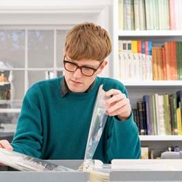 A person at a desk reading a book