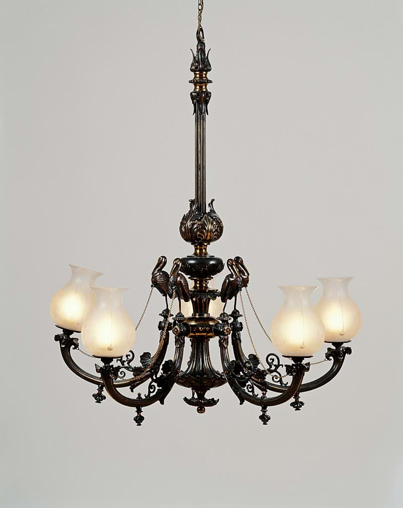 A hanging gasolier with five decorated arms, made from bronzed and gilt brass with frosted glass lampshades