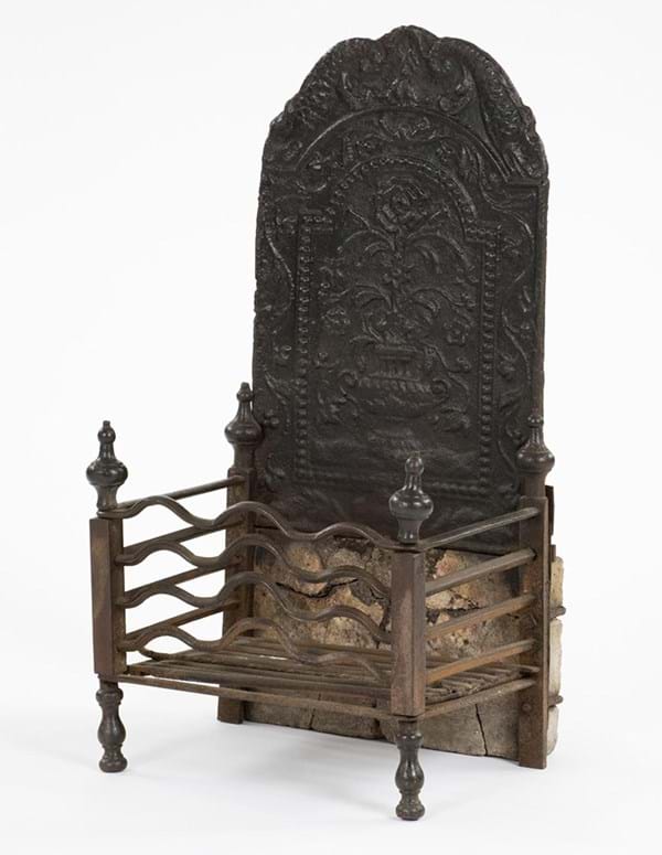 A cast iron coal and fireback with basket