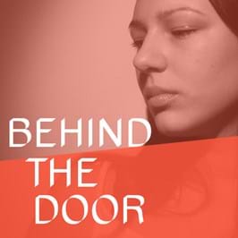 A person looking down, with text overlaid that reads 'behind the door'