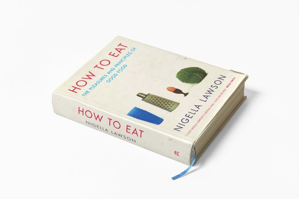 A white book titled 'how to eat' by Nigella Lawson