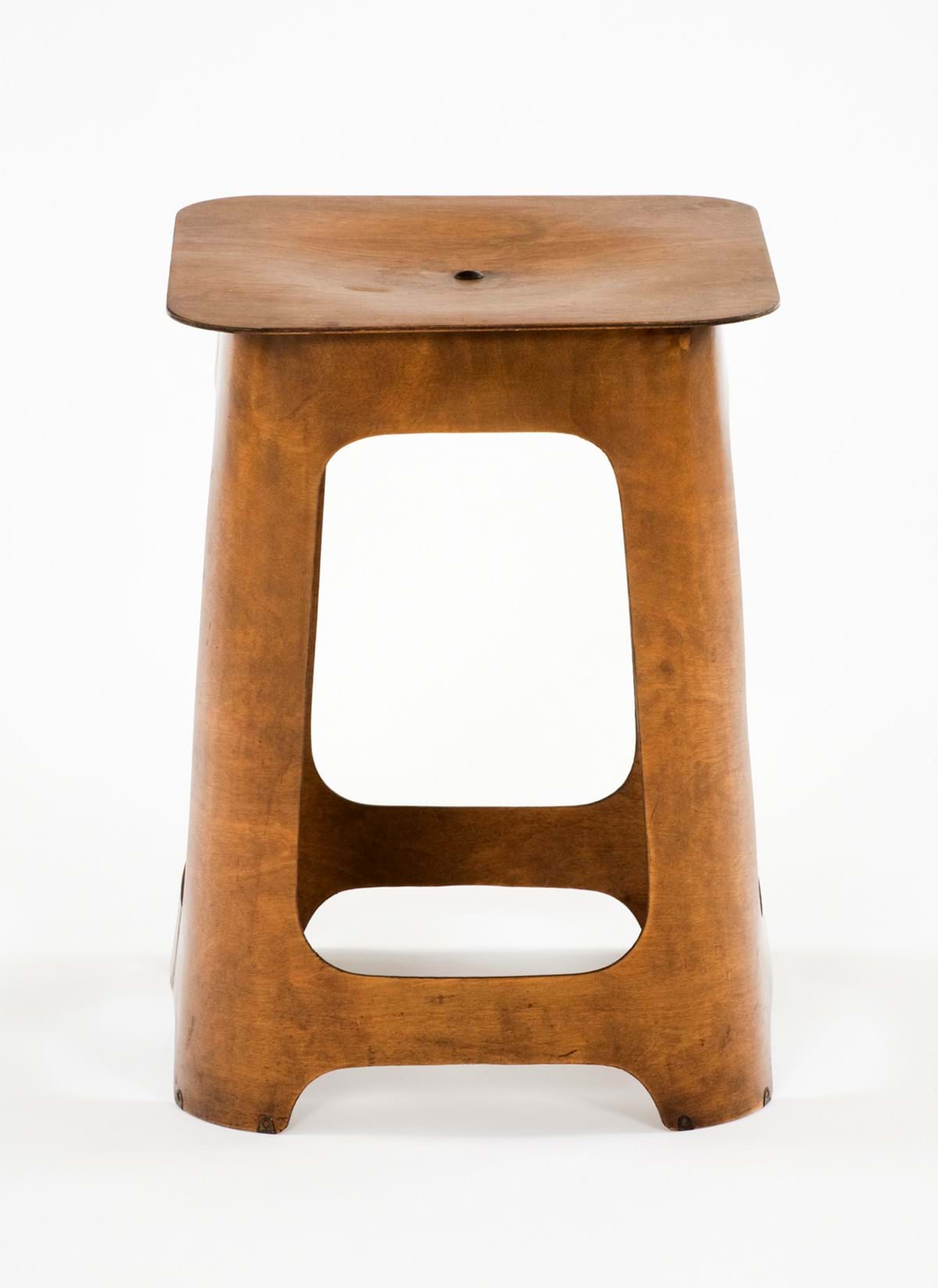 A brown plywood stool
