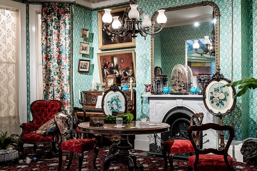 A room decorated in bright green colours with clashing floral patterns