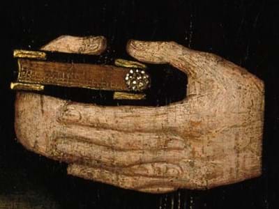 Close up of a painting showing hands clasping a prayer book