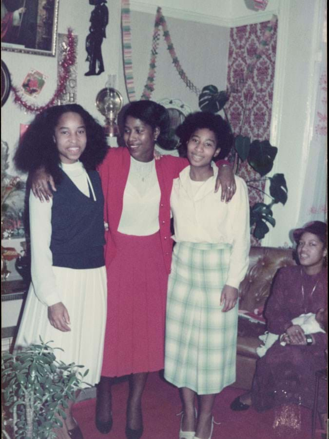 Three people standing together in a room with Christmas decorations 