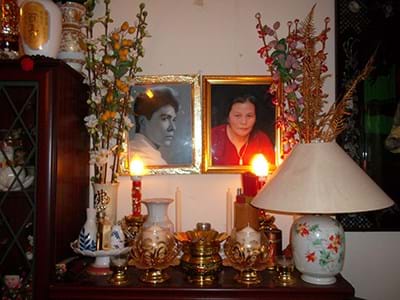 A Buddhist altar with two photo portraits and candles 