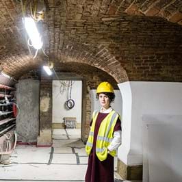 Director Sonia Solicari wearing a hard hat in the Undercroft with newly plastered walls