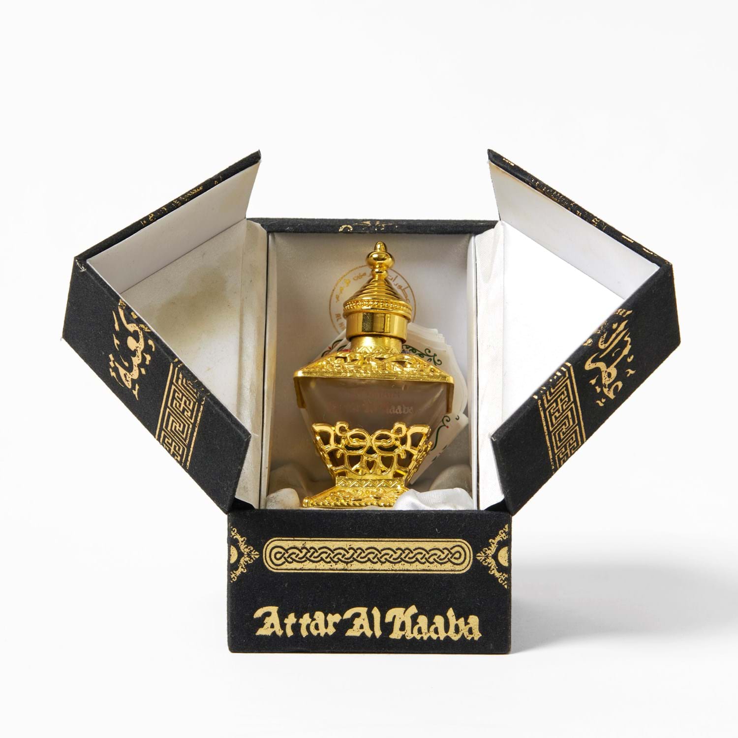 Black box with gold writing in English and Arabic script. Inside the box is a glass bottle with gold embellishments.