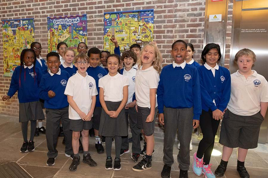 A group of young people celebrating with artwork behind them