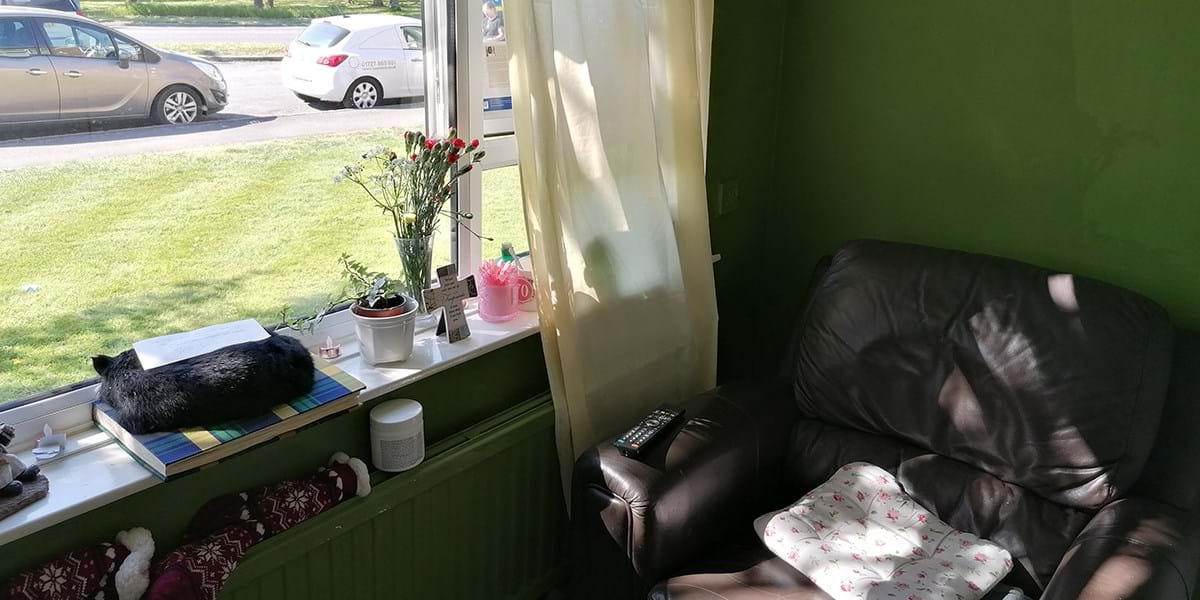 Large brown armchair by the window, view of cars outside