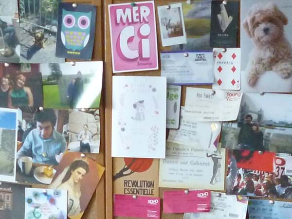 Close up of a noticeboard covered in postcards 