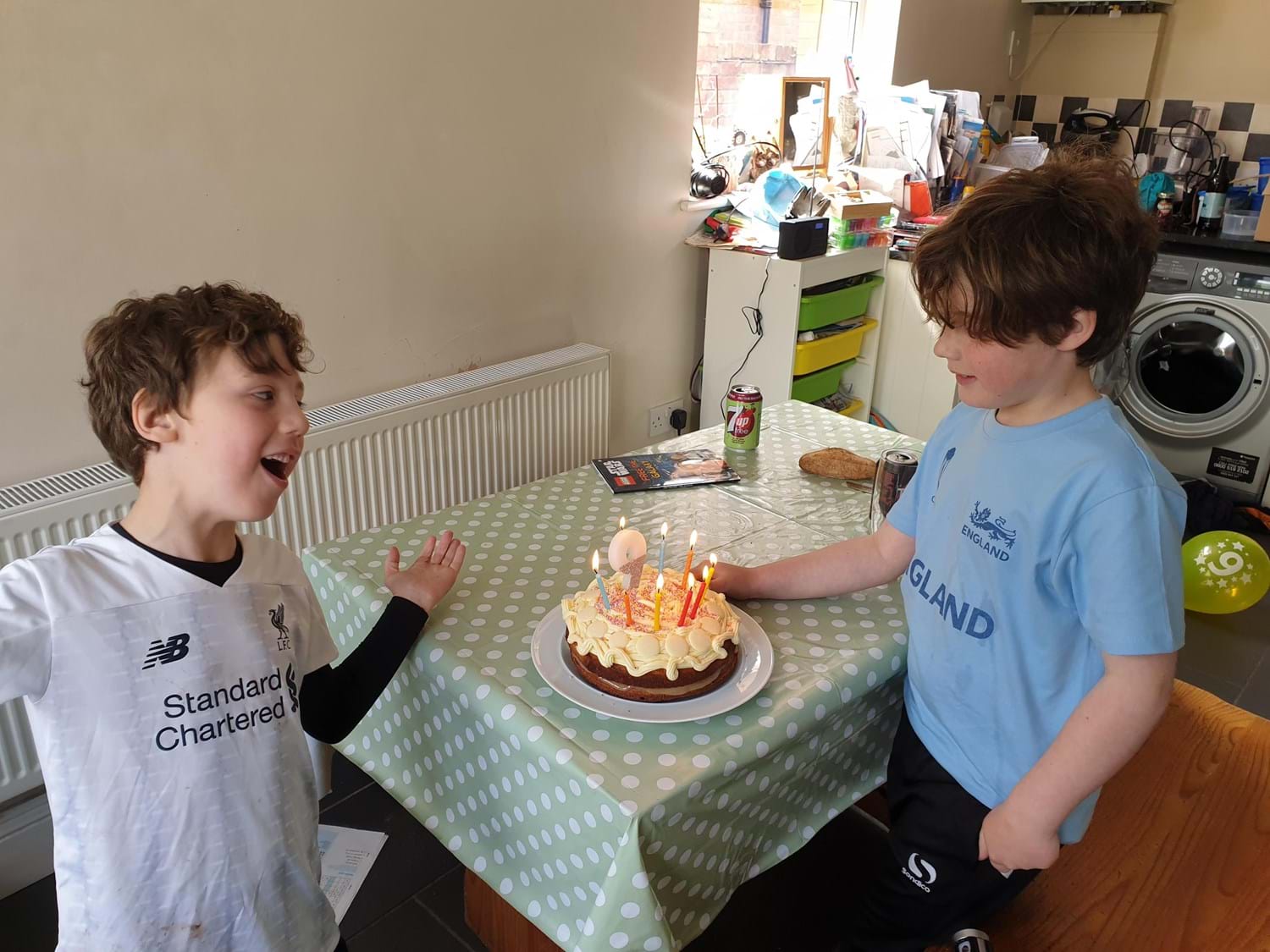 Two children with a birthday cake on a table
