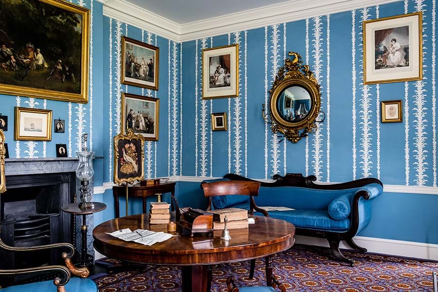 Georgian living room with blue patterned wallpaper and wooden furniture